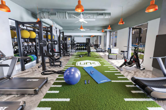 a gym with weights and other exercise equipment and a ball on the floor