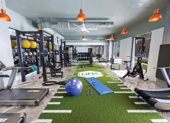 a gym with weights and other exercise equipment and a ball on the floor