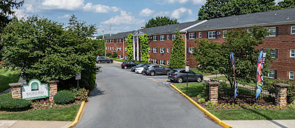 A street view of a residential area with cars parked on the side of the road.