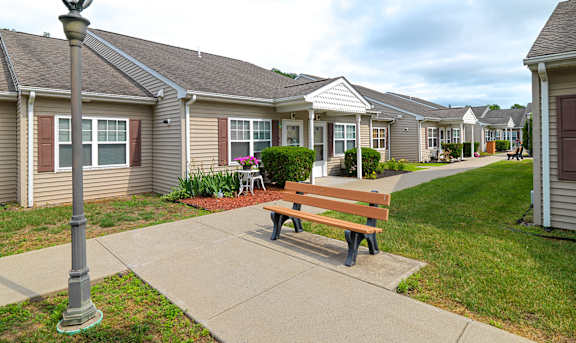 a park bench in front of a row of houses