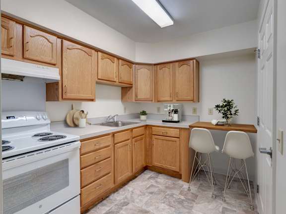 a kitchen with white appliances and wooden cabinets