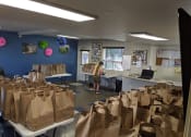 Thumbnail 13 of 13 - Grocery Bags sit on folding tables in the River Garden community room