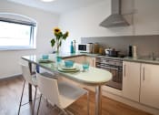 Thumbnail 8 of 8 - a kitchen and dining area with a table and chairs
