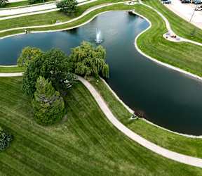 A fountain in the middle of a lake surrounded by trees.