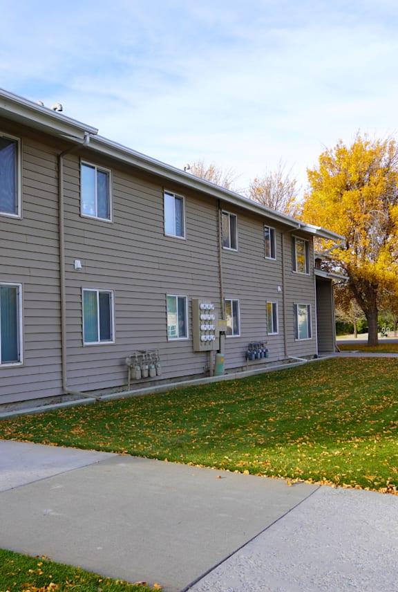 A building with a grey siding and a white roof. at Grand Manor Apartments , Grand Junction