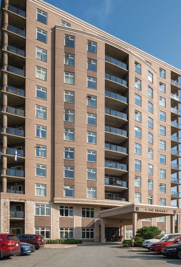A large apartment building with a parking lot in front.