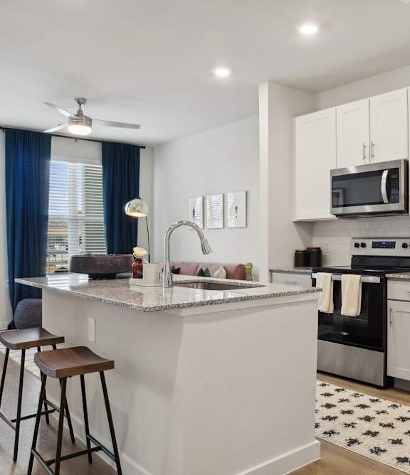 A kitchen with a white counter and stainless steel appliances.