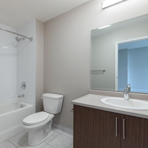 A white toilet sits next to a bathtub in a bathroom.