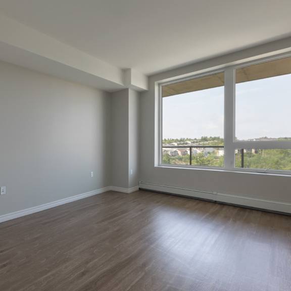 A room with a large window and wooden flooring.