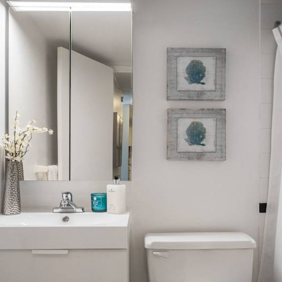 A white bathroom with a white sink and toilet.
