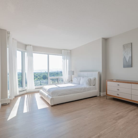 a bedroom with a bed and a dresser and a window