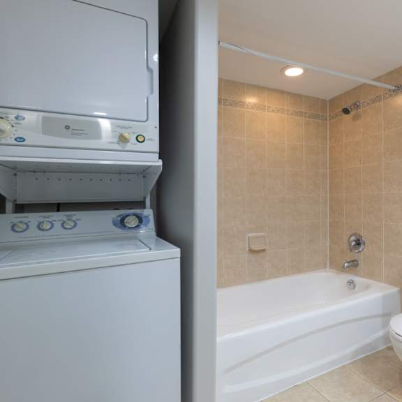 A white toilet sits next to a bathtub in a bathroom.
