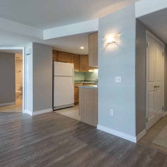 A kitchen with a white refrigerator and wooden cabinets.