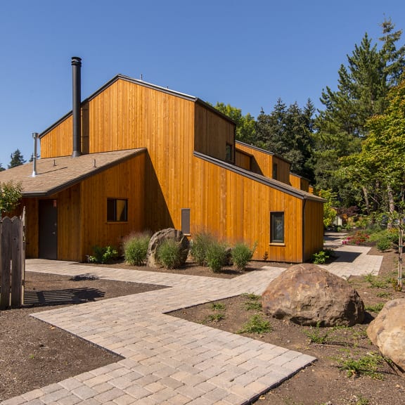 a wooden house with a courtyard and trees