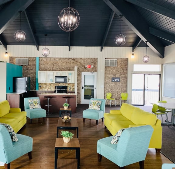 a large living room with yellow couches and blue chairs