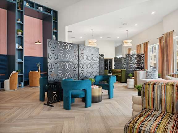 A modern living room with a blue and pink accent wall and a wooden floor.
