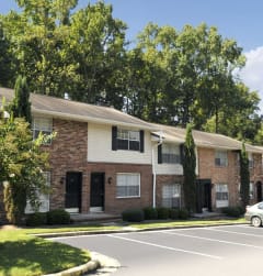 an apartment building with a parking lot and trees