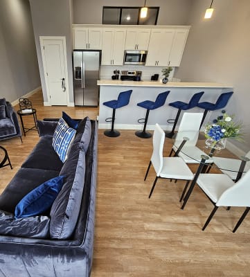 an overhead view of a living room with a kitchen in the background