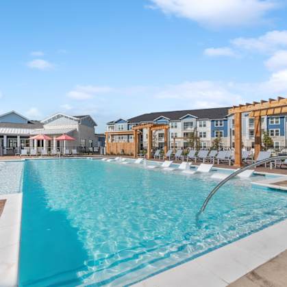 A large swimming pool with a slide in the middle of a resort.