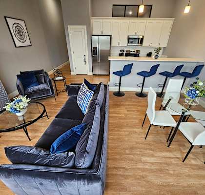 an overhead view of a living room with a kitchen in the background