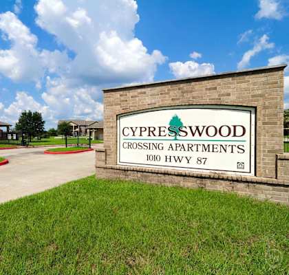 a sign for cypresswood crossing apartments in front of a building