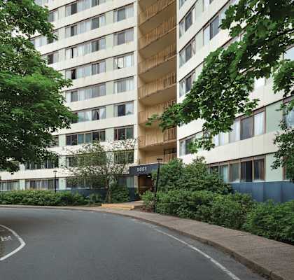 A tall residential building with a curved driveway in front.