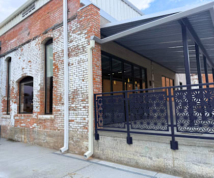 A brick building with a black iron fence in front.