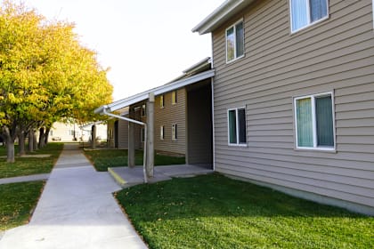 A building with a brown siding and a white door. at Grand Manor Apartments , Grand Junction