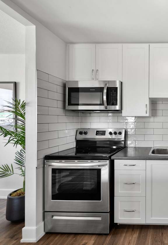 a kitchen with white cabinets and stainless steel appliances
