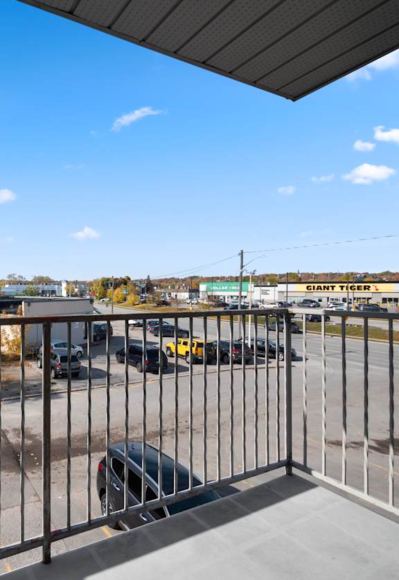 a balcony with a metal railing overlooking a parking lot