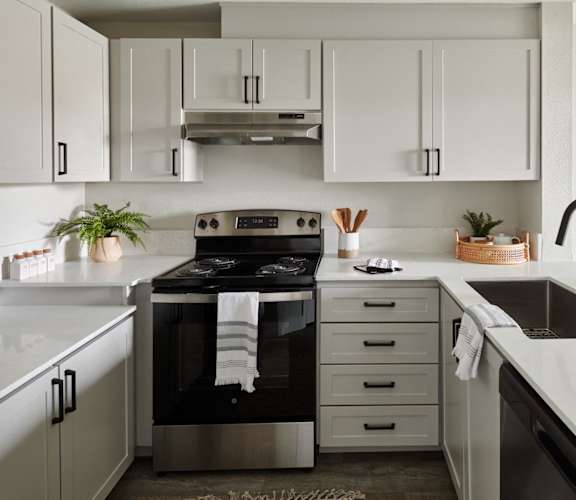 a white kitchen with black appliances and white cabinets