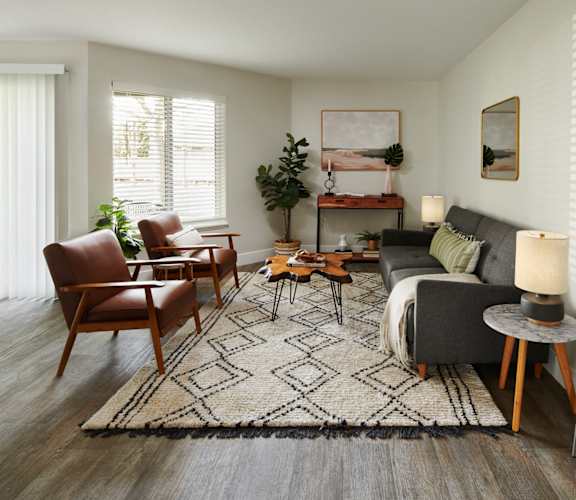 a living room with a couch and chairs and a rug