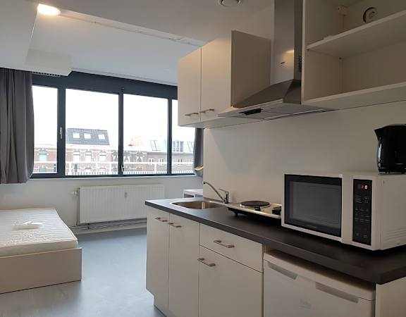 A kitchen with white cabinets and a black microwave.