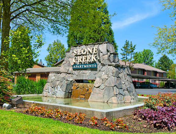 stone creek apartments sign in front of a building