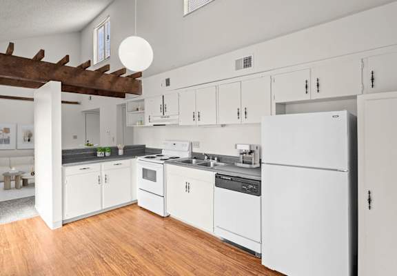 a kitchen with white cabinets and a wood floor