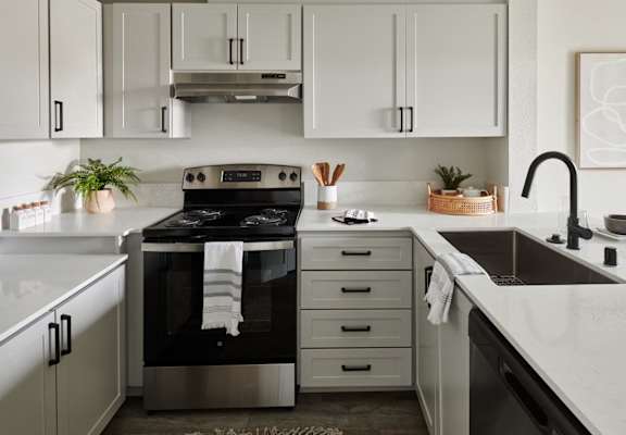a white kitchen with black appliances and white cabinets