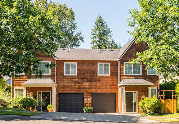 A two-story house with a garage and a driveway.