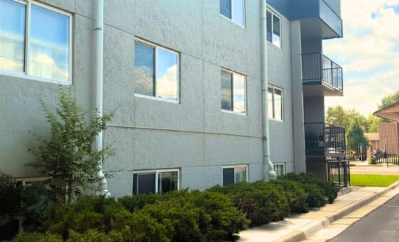 A modern apartment building with a balcony on the second floor.
