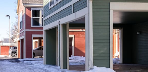 A green house with a garage door open. at Meeker Commons Apartments , Greeley