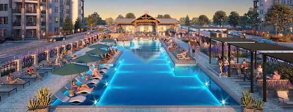 A large outdoor swimming pool with a lit up feature in the middle.