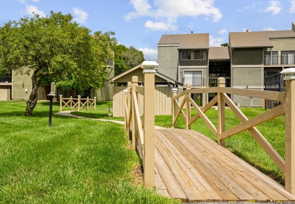 a wooden bridge leading to an apartment complex