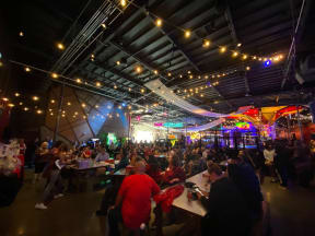 a large group of people sitting at tables in a large room with a large ceiling