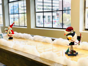 two christmas figurines on a table with snow on a window sill