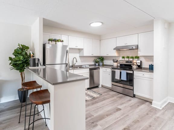 an open kitchen with stainless steel appliances and white cabinets