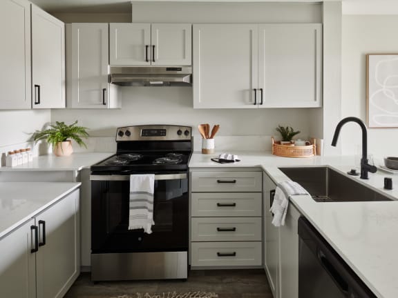 a kitchen with white cabinets and black appliances