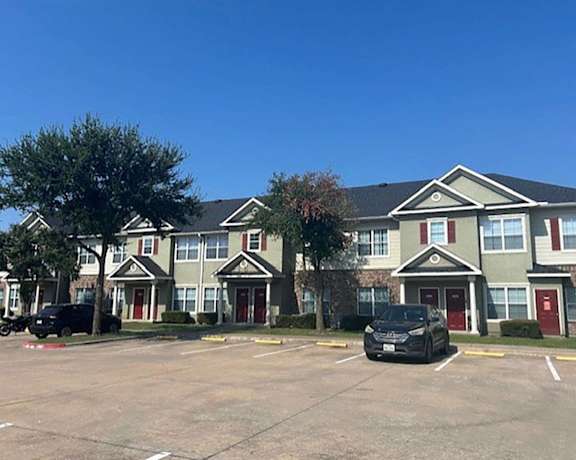 an empty parking lot in front of an apartment building