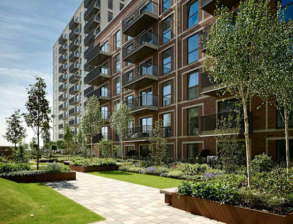 A modern apartment building with a well-maintained garden in front.