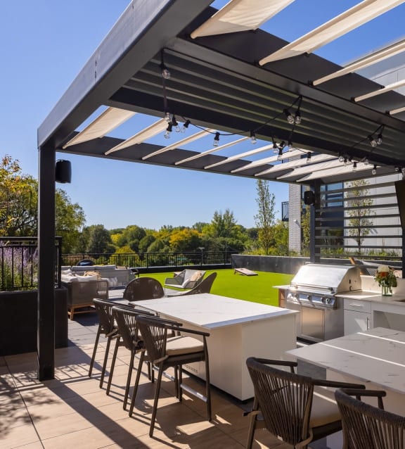 a patio with tables and chairs and a grill