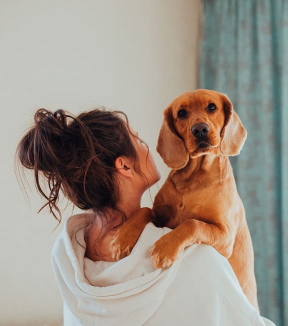a woman holding a brown dog on her shoulder at Hamilton at Eagleview, Exton Pennsylvania