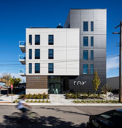 a view of the building from the street with a bicyclist in front of it